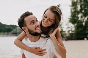 pareja joven sonriendo y abrazándose afectuosamente